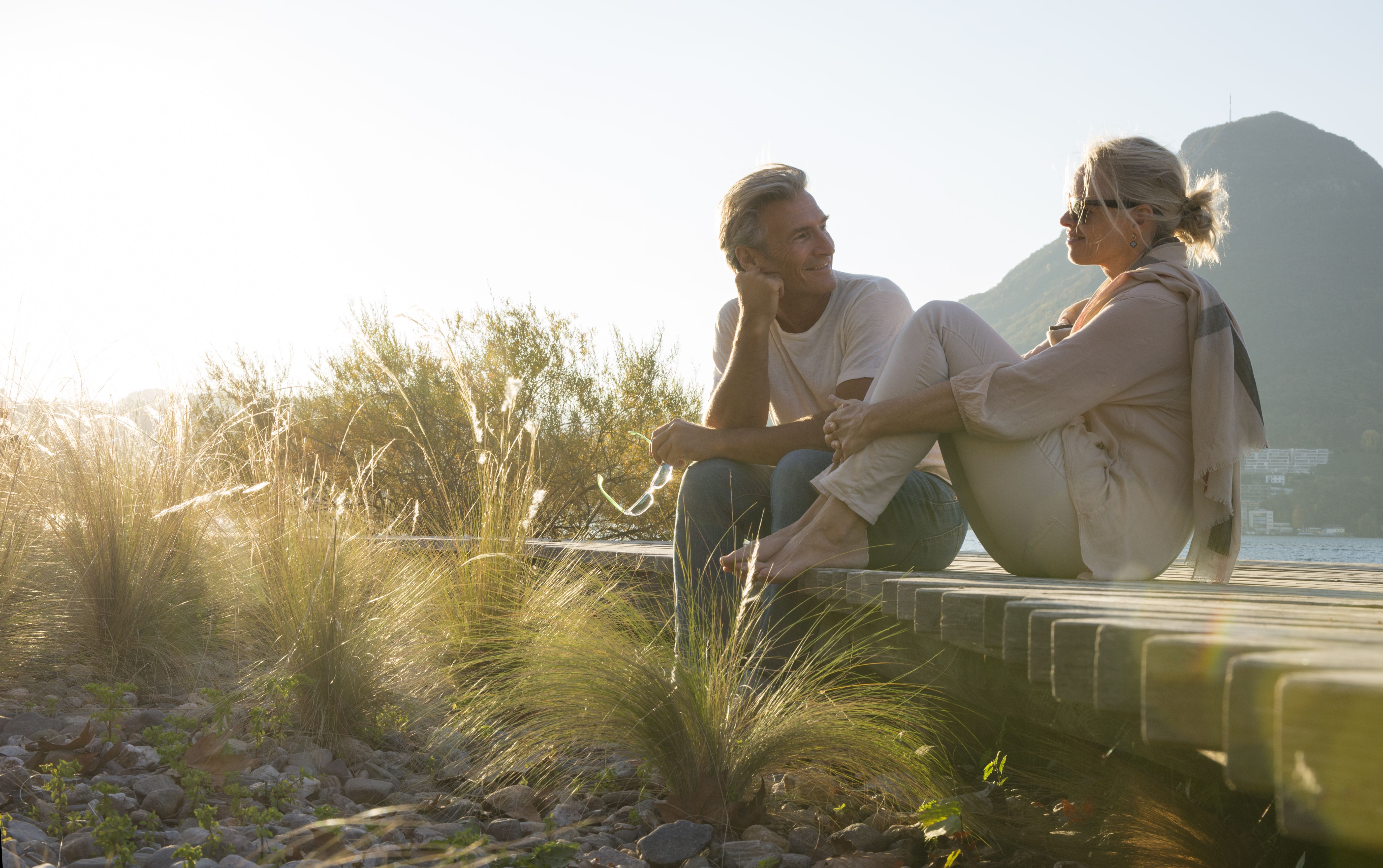 Un hombre y una mujer conversan al aire libre frente a un paisaje de montaña y se conocen a través de una búsqueda de pareja seria.