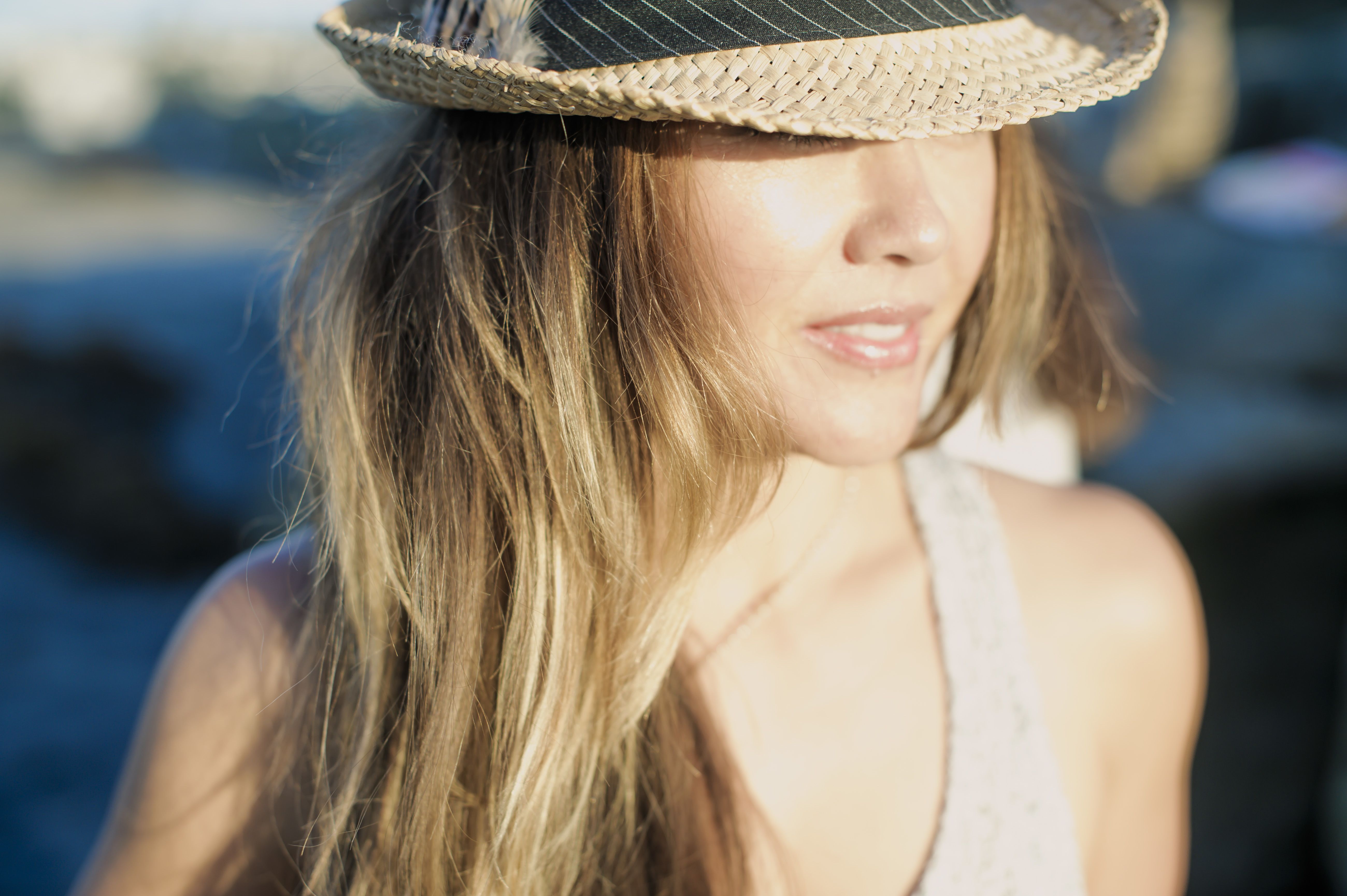 Mujer con un gran sombrero de verano, evocando la atracción, el encanto de una primera impresión y el deseo de encontrar una conexión auténtica.